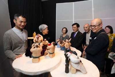 Ceramic artist Rosanna Li (second left) and her creative partner, Ng Hoi-chi (left), introduce their exhibits to the guests.