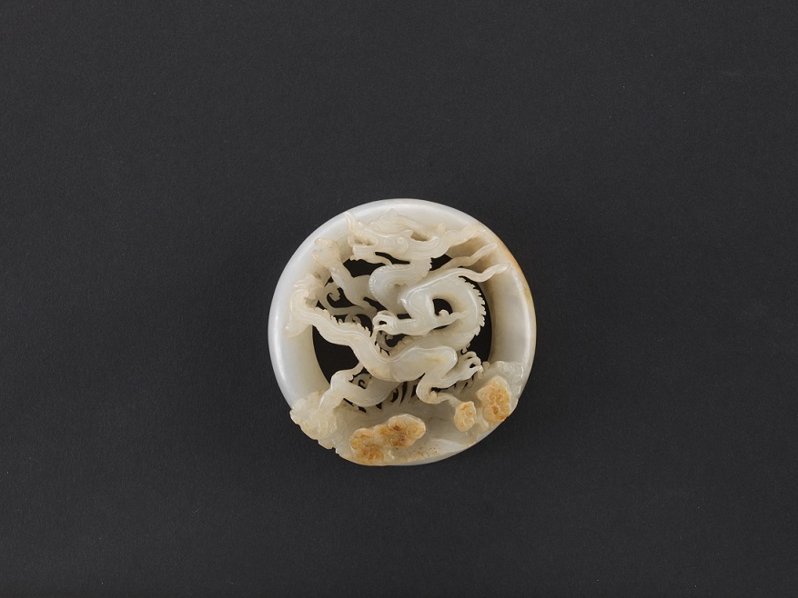 Circular jade ornament carved with dragon amidst clouds motif