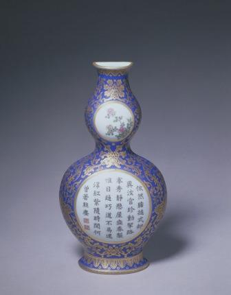 Gourd-shaped wall vase with famille-rose flowers and poem in reserved panels with gilded floral scroll pattern on blue ground