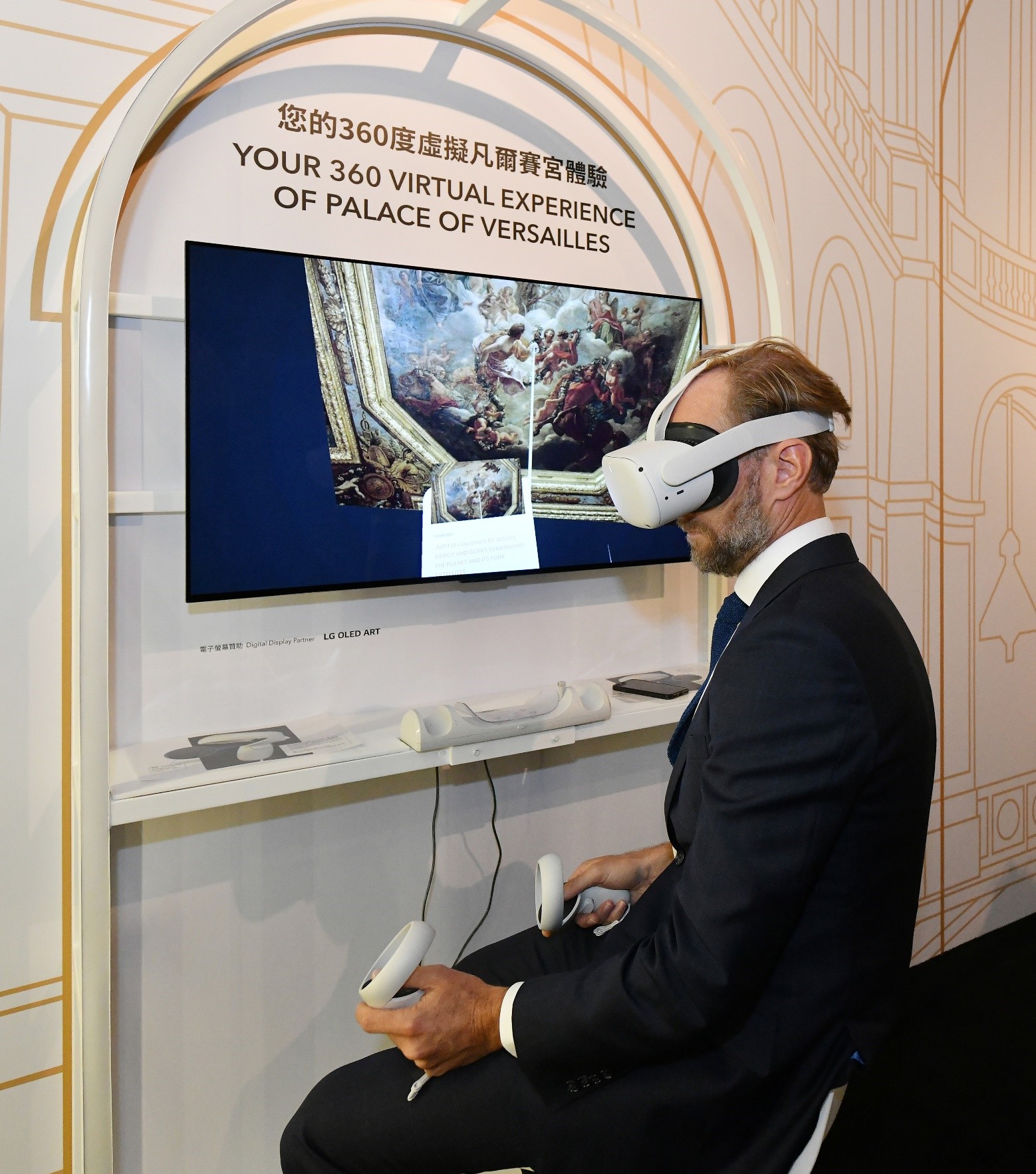 法國五月藝術節總經理馬沙維先生戴上VR眼鏡，體驗凡爾賽宮360度虛擬實景。